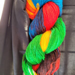 A skein of green/yellow/red/blue dyed sock yarn