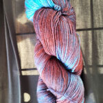 A skein of burgandy/sky blue dyed sock yarn